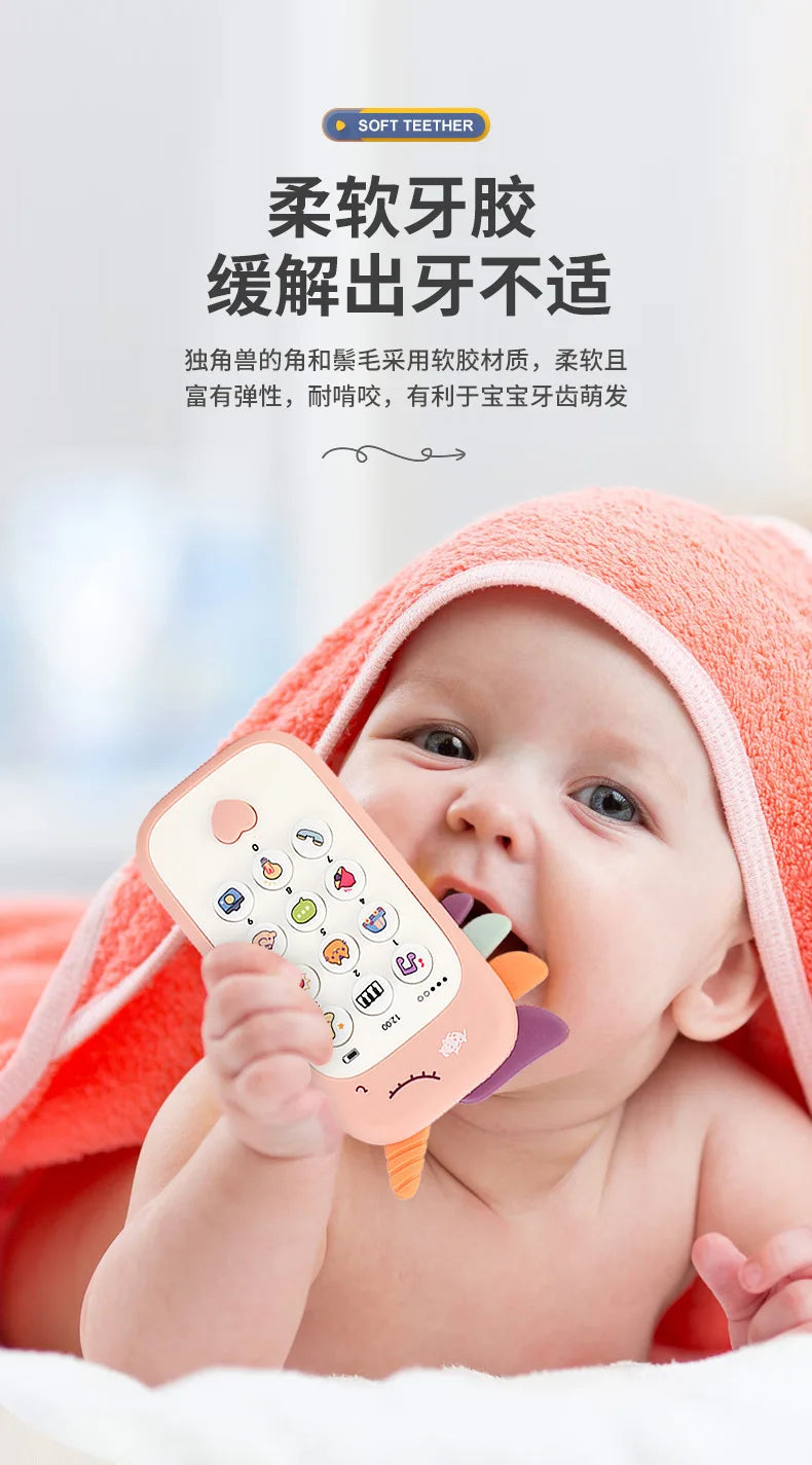 A baby is holding an orange silicone teether toy with various buttons and shapes, resting on a bright orange towel.