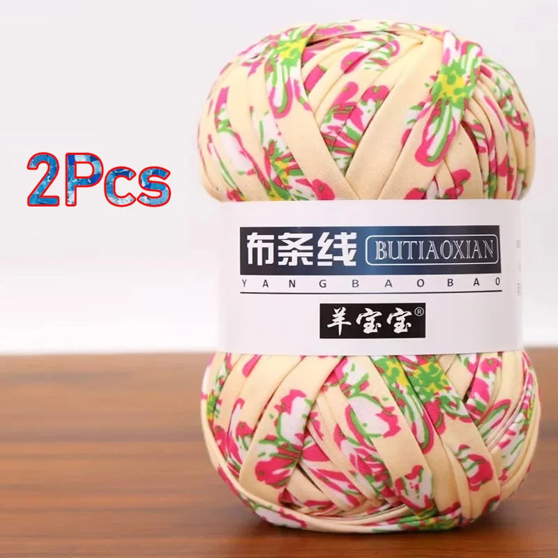 A ball of pink and green patterned soft chunky t-shirt yarn for crochet and knitting, packaged as a 2-pack.
