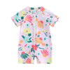 A pink baby rash guard swimsuit with a floral print featuring orange, green, and yellow flowers.