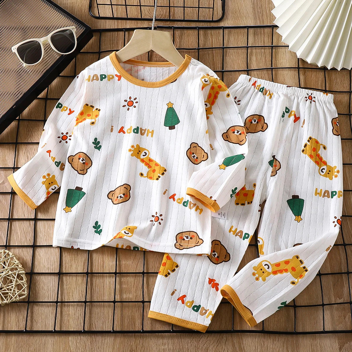 White long sleeve cotton pajama set for kids featuring happy animal prints and text
