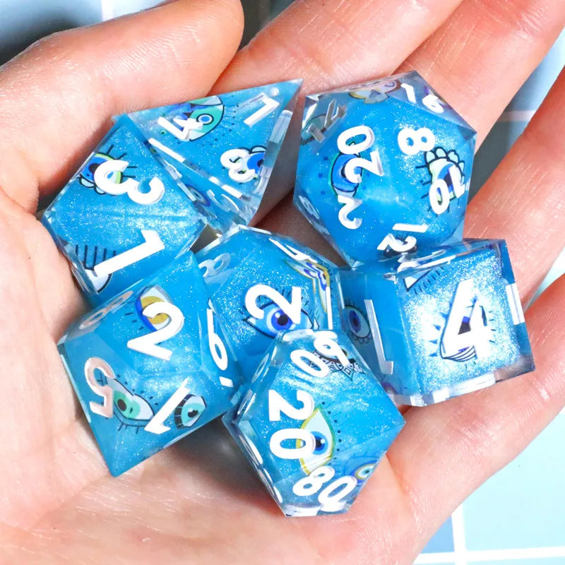 A hand holds a set of blue resin polyhedral dice with various numbers and symbols.