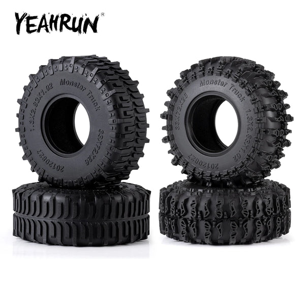 A set of four black Monster Truck mud terrain tires for an RC crawler.