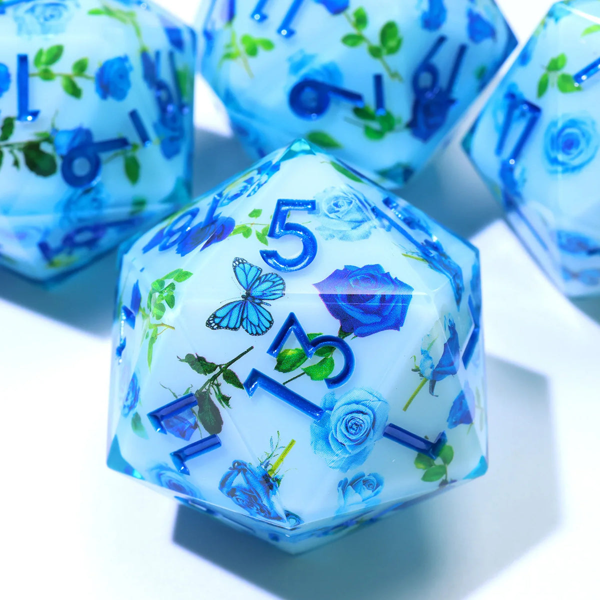 A translucent blue resin D20 die featuring a floral design with blue and purple liquid swirls.