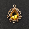Gold plated water droplet charm featuring a faceted yellow crystal gemstone and an ornate flower setting.