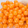 A bulk set of bright orange plastic ocean ball pit toys in a white basket.