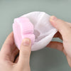 A hand holds a translucent pink liquid candle and soap colorant bottle, showing its texture and volume.