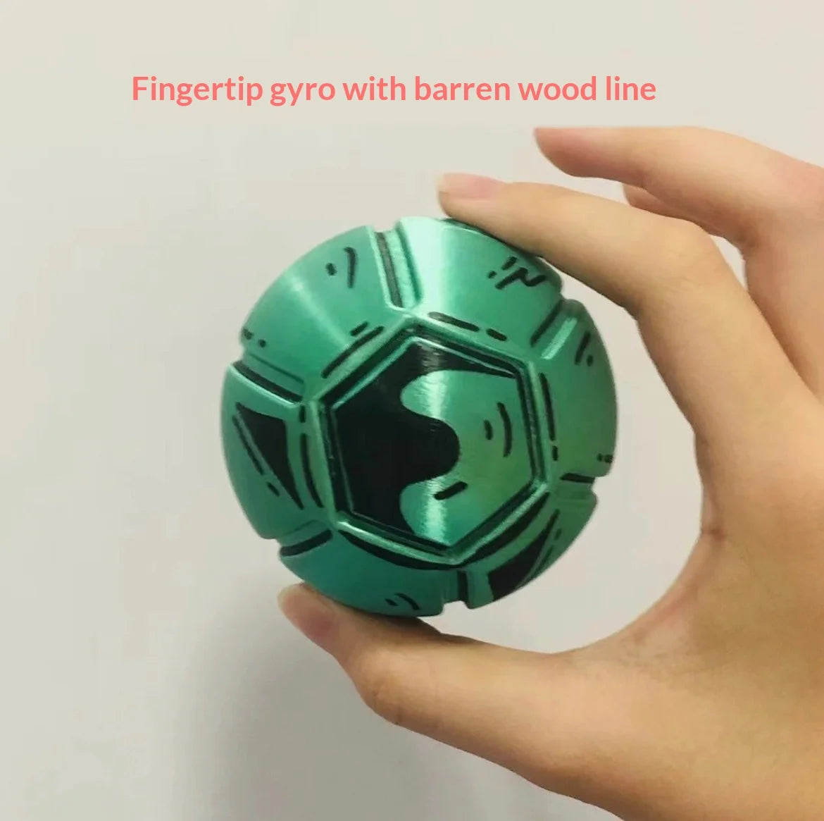 A hand holds a green fidget toy with a barren wood line design.