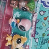 A plastic packaging shows three small animal figures, including a brown and green creature, for sale.