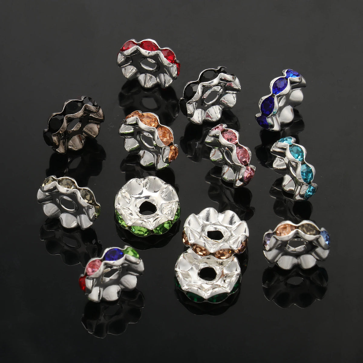 A collection of silver spacer beads featuring various colored crystal rhinestones, including red, green, blue, and amber.