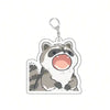 A cute raccoon acrylic keychain with an open mouth expression.