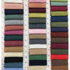 A collection of various colored linen napkins displayed in a vertical row.