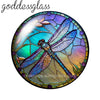Round glass cabochons shaped like a dragonfly in iridescent blue and green colors.