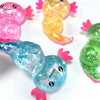 A collection of colorful glitter axolotl squishy stress relief toys in pink, yellow, and blue.