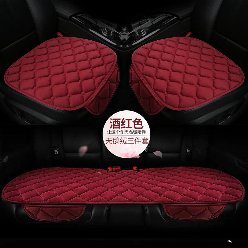 A set of three red quilted plush anti-slip car seat cushions shown in the interior of a car.