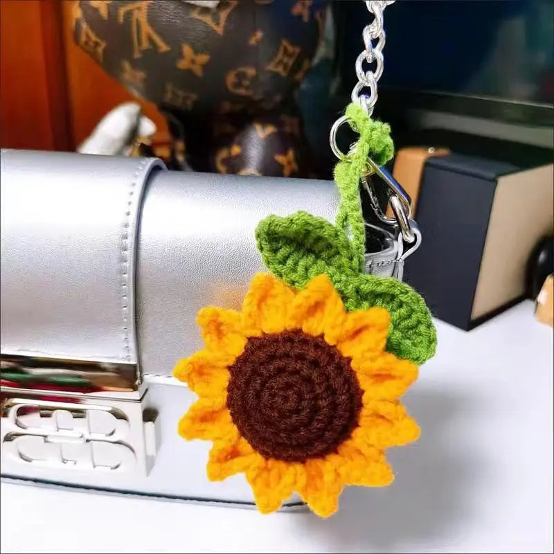 Handmade crochet sunflower charm attached to a silver car mirror.
