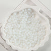 White oval glass rice grain beads for jewelry making displayed in a mold.