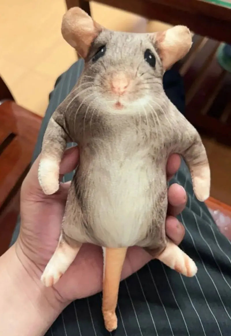 A gray and white lifelike skeleton plush toy resembling a small rodent is held in a person's hand.