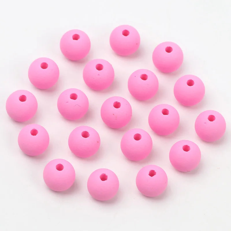 A collection of pink matte acrylic beads shaped like macarons for jewelry making