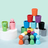 Eine Stapel bunte Holzbecher und Sortierspielzeug für Kleinkinder in verschiedenen Grüntönen, Pink, Blau, Lila und Schwarz.