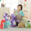 A collection of colorful soft plush dinosaur toys, including purple, pink, and green triceratops figures, displayed on a whit