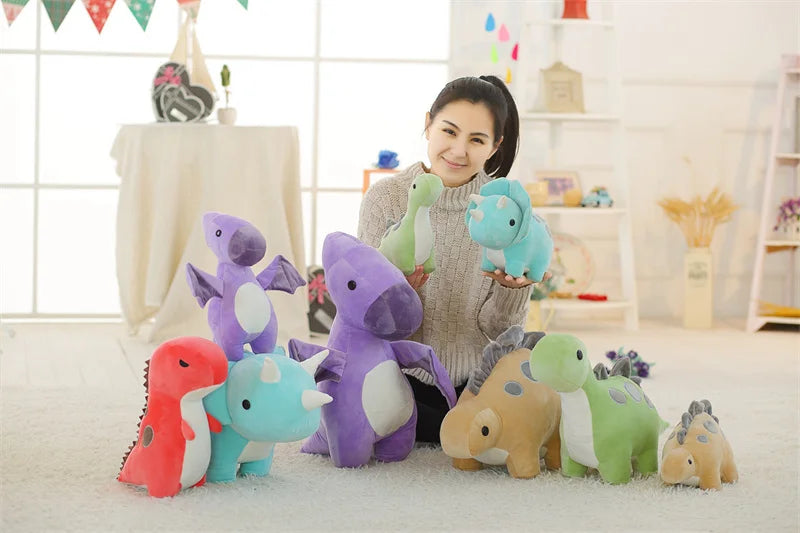 A collection of colorful soft plush dinosaur toys, including purple, pink, and green triceratops figures, displayed on a whit