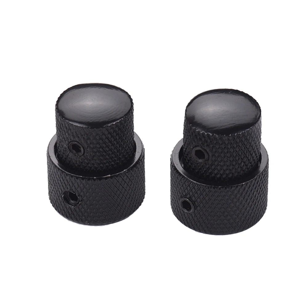 A pair of black dual concentric stacked control knobs for electric guitar and bass.