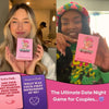 A woman holds a pink box of an interactive couples drinking game titled The Ultimate Date Night Game for Couples.