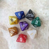 A collection of ten acrylic polyhedral dice in various colors and shapes scattered on a white surface.