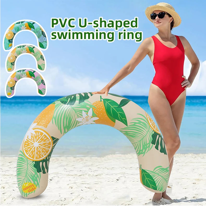 A woman is holding a yellow and green PVC U-shaped swimming ring on a beach with blue water in the background.