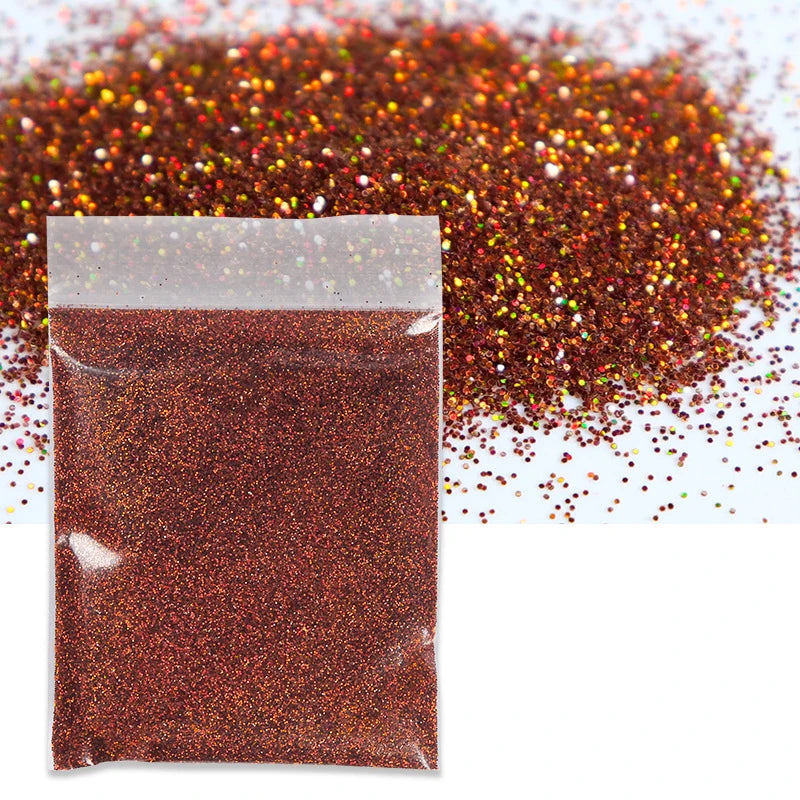 A small plastic bag filled with reddish-brown holographic glitter powder next to a loose pile of the same material.