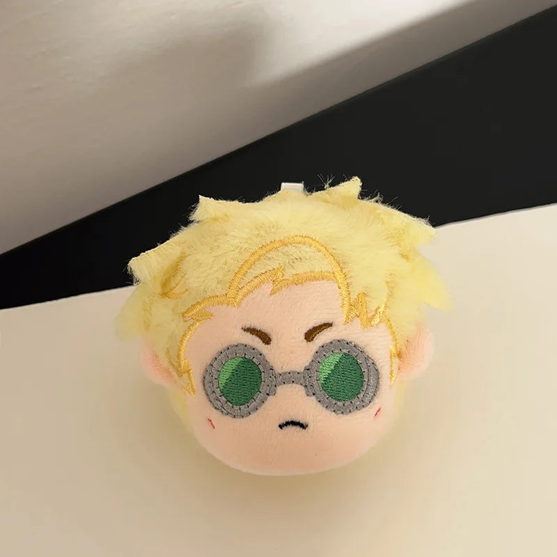 A yellow anime plush keychain pendant of a character with spiky hair and green glasses.