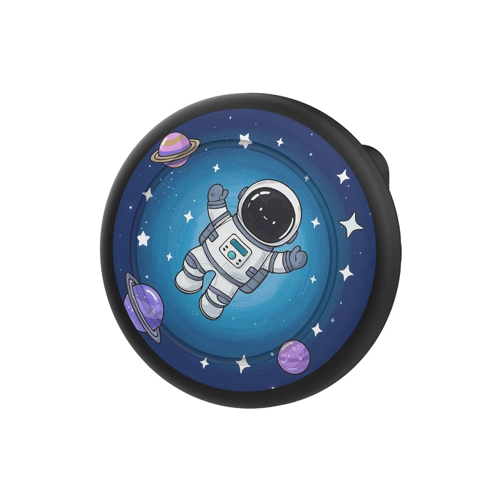 A silicone airtag safety pin holder with a dark background featuring a space scene including planets and a spacecraft.