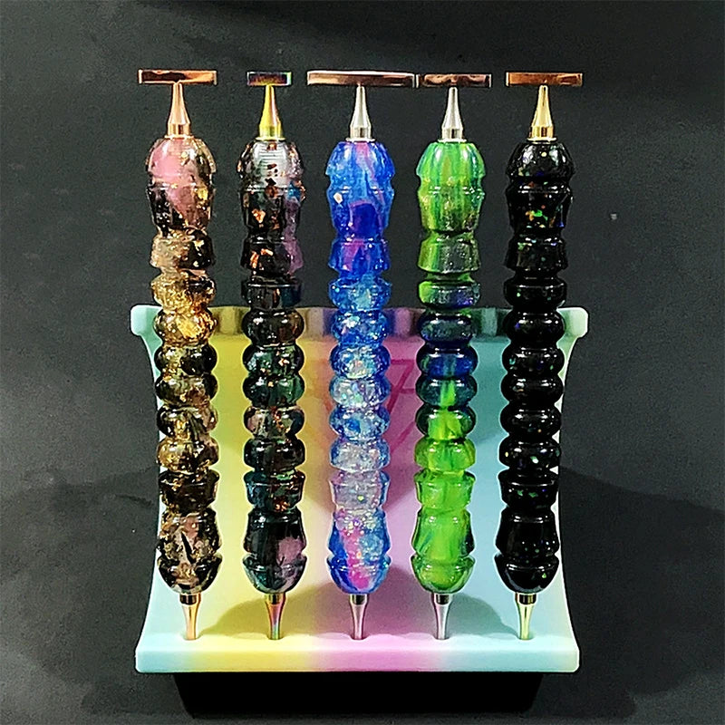A set of five colorful diamond painting pens with stainless steel tips displayed vertically on a white tray.