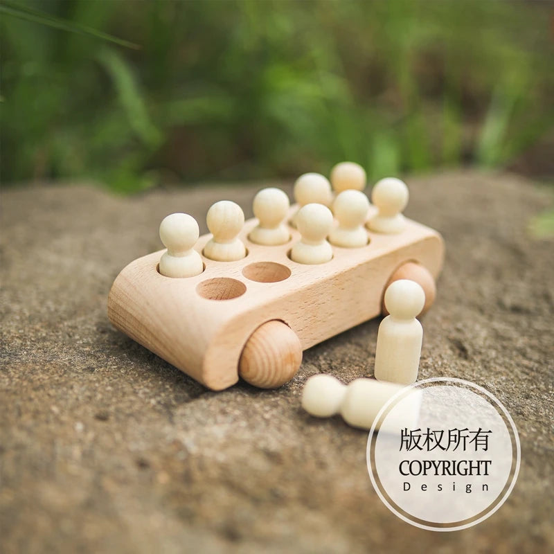 A wooden train set with numbered cars is placed on a stone surface.