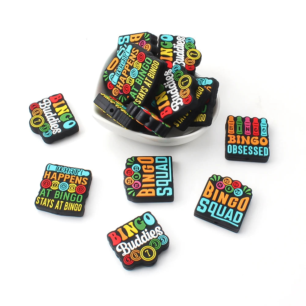 A collection of black and yellow silicone bingo beads and tiles for DIY jewelry and accessories.