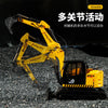 A yellow die-cast toy excavator model is shown operating in a construction environment.