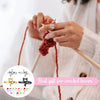 Hands crafting a red yarn with an adjustable cat-ear ring for knitting and crochet