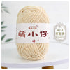 A ball of light beige chenille yarn labeled with Chinese characters for knitting and crochet.