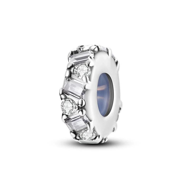 A round sterling silver charm bead featuring a central blue stone surrounded by clear diamond-cut accents.