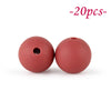 Two round, reddish-pink silicone beads are shown against a white background.