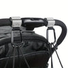 Close-up of heavy-duty stroller hooks attached to a black fabric bag or backpack.