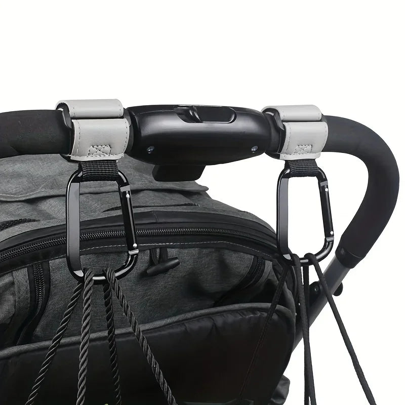 Close-up of heavy-duty stroller hooks attached to a black fabric bag or backpack.
