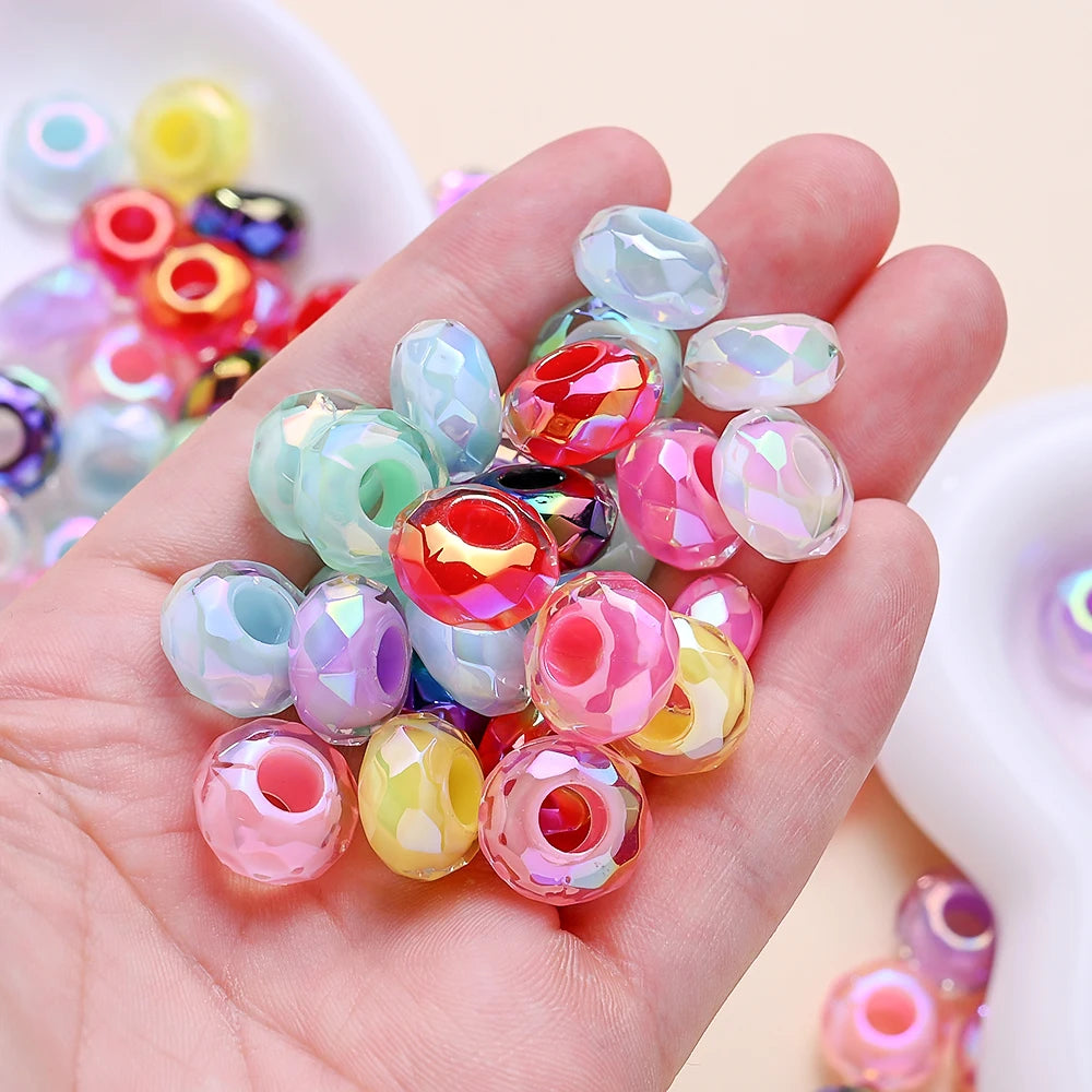 Une main tient une collection de perles de séparation en acrylique facettées colorées pour la fabrication de bijoux DIY