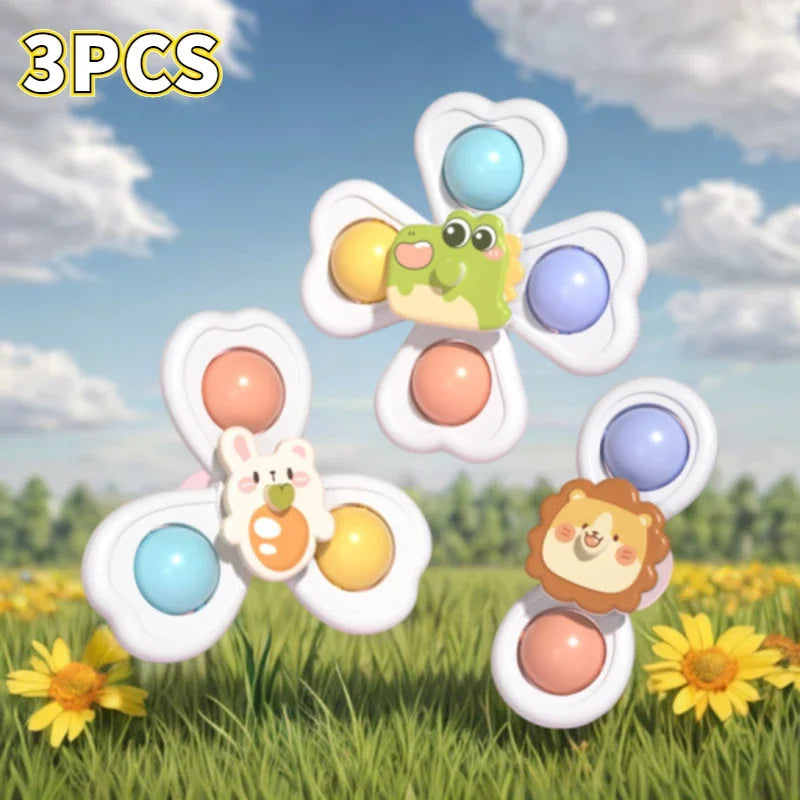 Drei Saugnapf-Spinner-Spielzeuge mit niedlichen Tierfiguren und bunten Punkten auf einem grasigen Hintergrund.
