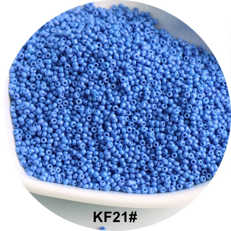 A pile of bright blue 1.5mm solid glass seed beads for jewelry and craft.