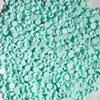 A pile of light mint green plastic bead filler for DIY squishy toys and stress relief crafts.