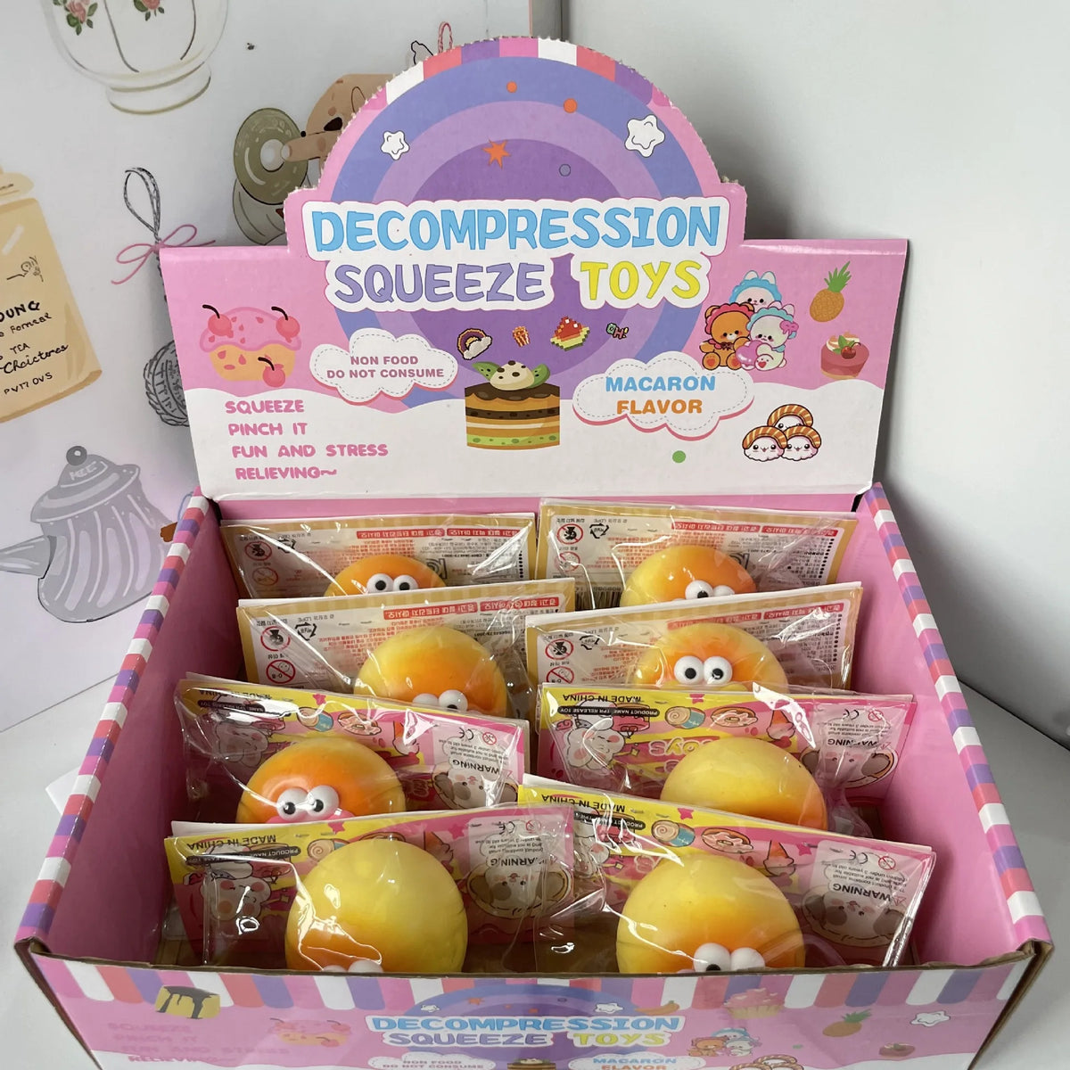 A box of Decompression Squeeze Toys featuring various food-themed squishy toys and stress relief items.