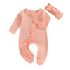 A peach knit romper for a baby girl with ruffled details and a matching pink headband.