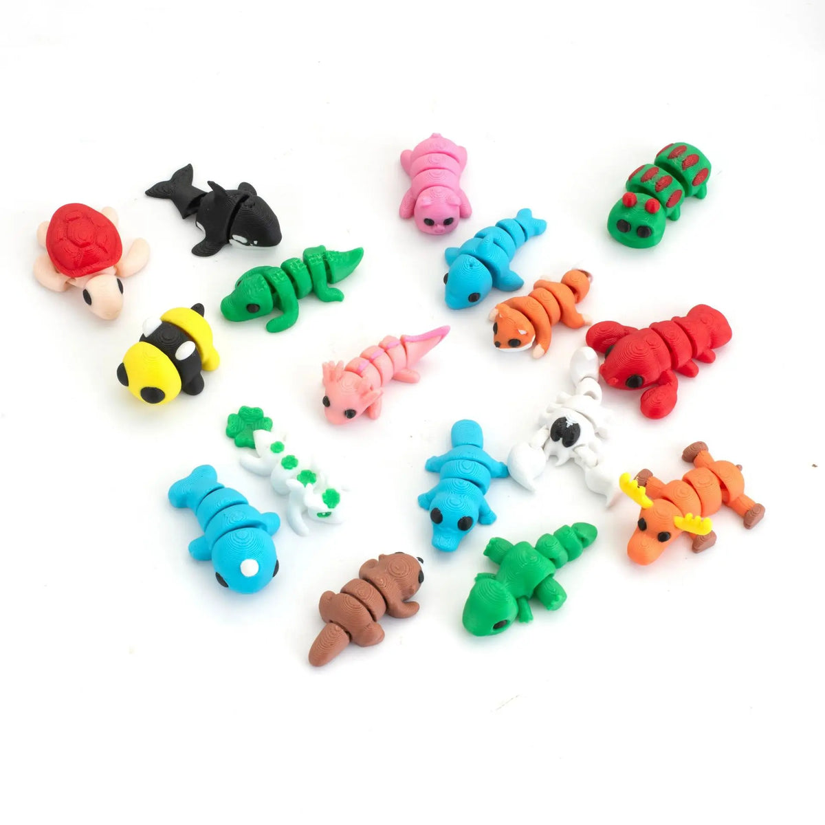 A collection of colorful poseable 3D printed animal figurines including a pink hedgehog, green lizard, black cat, and various