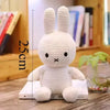 A white Miffy plush toy with long ears sitting on a wooden surface.